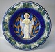 1925 Den kongelige porcelænsfabriks Store Juleplatter af Fajance fra Aluminia 
1291-1227 Julerelief 1925 Stående engel med bækken R. Harboe 31,5 cm

