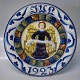 1923 Den kongelige porcelænsfabriks Store Juleplatter af Fajance fra Aluminia 
1235-1175 Julerelief 1923 Engel med skriftbånd R. Harboe 31,5 cm 
